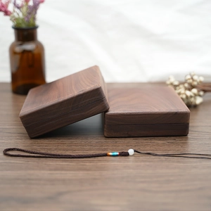 Macro shot of two handcrafted dark wood jewelry boxes with natural grain textures