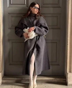 Dettaglio del cappotto di lana grigio scuro con ampi revers e silhouette strutturata