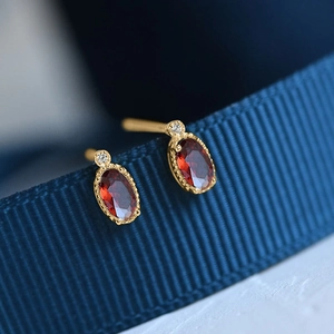 Minimalist gold stud earrings with oval red gemstone and tiny white diamond accents