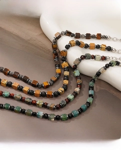 Detail of square natural tiger eye and lava stone beads on a boho men's bracelet