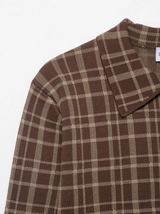 Detail eines braun-karierten Strick-Poloshirts mit klassischem Kragen und Textur