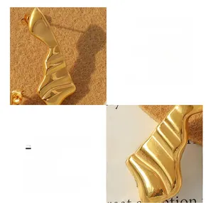 Détail macro de boucles d'oreilles vagues irrégulières en acier titane plaqué or 18K