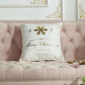 Christmas cushion cover with golden Merry Christmas text on a velvet sofa