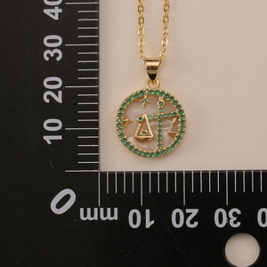 Detail view of 20mm Libra zodiac necklace with green stones and mother of pearl inlay
