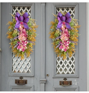 Detail of hanging artificial purple hydrangeas and silk bow on a vintage door