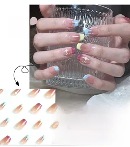 Macro detail of French press-on nails with blue dripping paint and white star patterns
