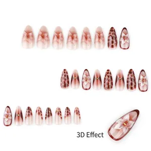 Faux ongles amande marbre brun avec art floral 3D et perles dorées sophistiquées