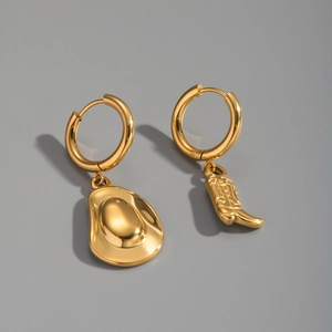 Detail showing asymmetrical 18K gold plated earrings with a flat pendant and boot charm