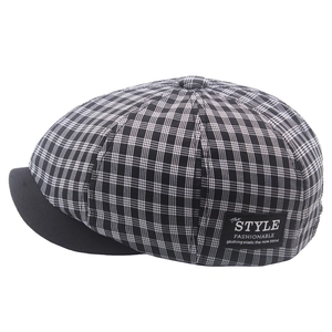 Detail of vintage black and white plaid newsboy hat with a side fashion label tag