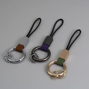 Détail de porte-clés de voiture en cuir marron, violet et vert avec anneaux métalliques