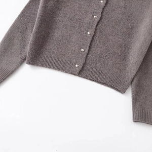 Dunkelgraue Strickjacke mit silbernen Metallknöpfen und Rippbündchen auf weißem Grund