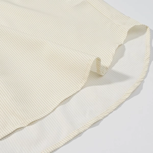 Detail of the curved hem and beige striped pattern on cotton fabric clothing