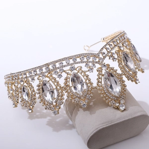 Macro shot of gold baroque bridal crown with large marquise crystals on a grey stand