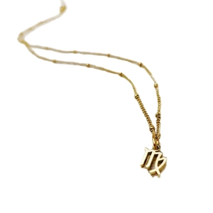 Gold stainless steel Virgo zodiac pendant necklace on a minimalist beaded chain.