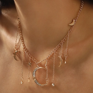 Detail of multi-layered gold moon and star necklace with sparkling rhinestones on model