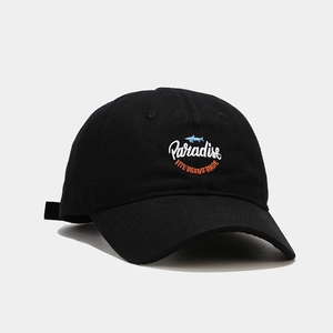 Dettaglio cappellino in tela nera con ricamo Paradise e logo squalo su sfondo grigio
