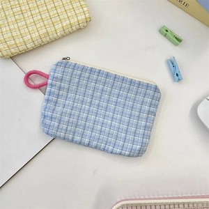 Close-up of blue checkered fabric pouch with pink rope pull and zipper closure detail