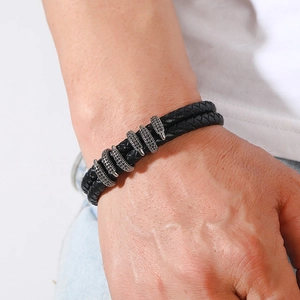 Close-up of black braided leather bracelet with silver metal hardware and micro-pave crystals