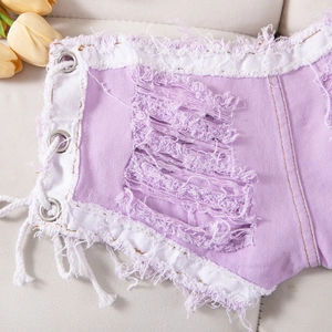 Detalle de los shorts denim morados de tiro bajo con bordes desgastados y cordones laterales