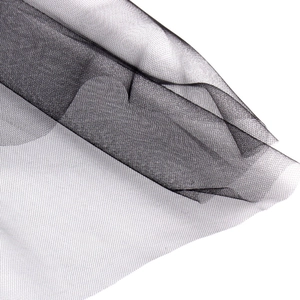 Macro shot of delicate black tulle mesh fabric showing fine texture for wedding accessories