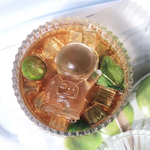 Creative astronaut shaped ice cube floating in a glass drink with mint and lime
