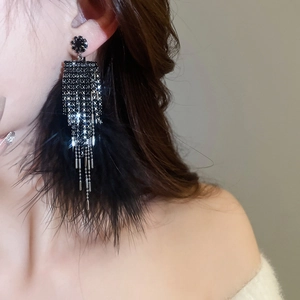 Detail of dark style ear cuff featuring black rhinestones and soft feather tassels