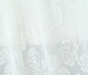 Macro de tissu texturé blanc avec broderie de motifs floraux de roses en relief 3D