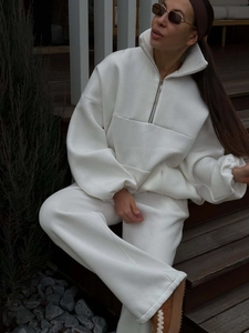 Women's white two-piece sweatsuit with half-zip sweatshirt and wide-leg trousers