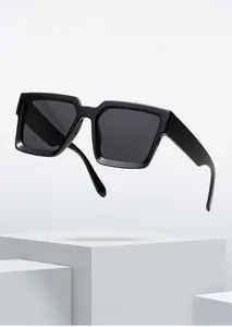 Detail of square black sunglasses on a minimalist white geometric display stage