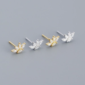 Macro shot of geometric zircon stud earrings in gold and silver finishes