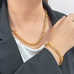 Golden stainless steel U-link necklace and bracelet jewelry set for women worn with suit