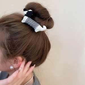 Detail of fabric dachshund hair clip with black and white gingham pattern on hair