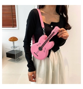 Detailed view of a pink guitar-shaped crossbody bag worn with an adjustable strap