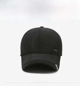 Detail of black diamond-quilted baseball cap with metal accent and warm lining