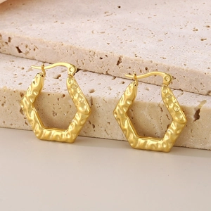 Détail de la texture ondulée irrégulière sur des boucles d'oreilles en titane doré