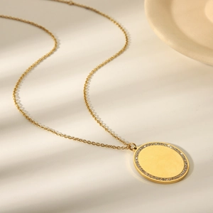 Minimalist 18k gold stainless steel necklace featuring a crystal paved oval pendant