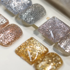 Macro detail of high-density metallic silver and gold glitter nail polish swatches