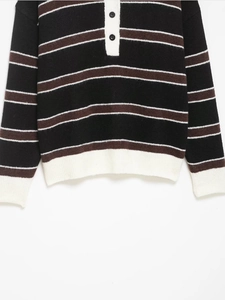 Detail of striped knit sweater showing polo collar with buttons and ribbed texture