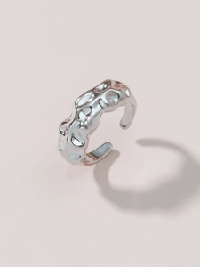 Macro detail of silver plated adjustable ring featuring irregular wrinkled texture surfaces