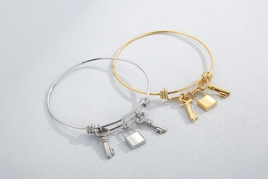 Detailed shot of gold and silver stainless steel bangles with lock and key charms