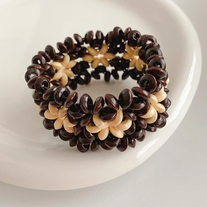 Macro view of bohemian stretch bracelet showing detailed coconut shell flower pattern weaving