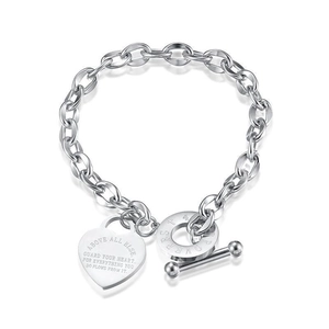 Detail of silver heart charm with Proverbs 4:23 engraving on t-bar chain bracelet