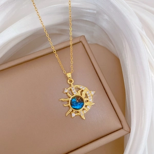 Detail of gold star and moon pendant necklace with blue gem and sparkling crystals