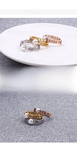 Detailed view of geometric pearl rings in gold, silver, and rose gold stainless steel