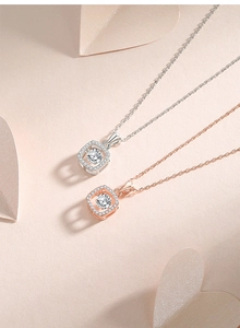 Macro shot of silver and rose gold sugar cube necklaces with floating moissanite pendants