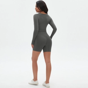 Detail der High-Waist Peach-Lift Shorts und des schmalen Yoga-Sets in Dunkelgrau