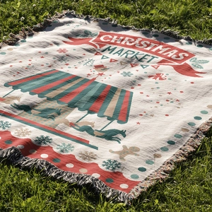 Detail of Christmas Market woven blanket with festive patterns and tassel edge on grass