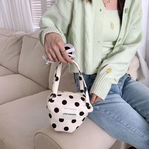 Close-up of a vintage polka dot canvas handbag with top handle and zip closure