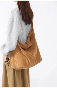 Brown corduroy tote bag showing large capacity and textured fabric on a model