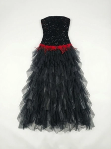 Detail of red feather waist decor and black sequins on the mesh evening ball gown
